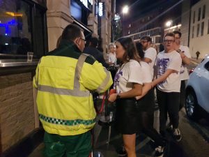 A first aider watches as freshers enter a bar